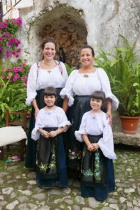 Elisa und Alessia mit ihren Töchtern Aice und Luzia in traditionellen Trachten in Olieni